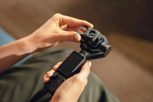 Load image into Gallery viewer, DJI Osmo Pocket 4P dual-lens gimbal camera with touchscreen shown next to an Osmo clip-on accessory