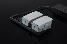 गैलरी व्यूवर में इमेज लोड करें, Two DJI Mavic Air 2 Drone Batteries Are Shown In A Charging Hub, Which Is Connected To A Power Adapter.
