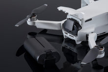 ಗ್ಯಾಲರಿ ವೀಕ್ಷಕಕ್ಕೆ ಚಿತ್ರವನ್ನು ಲೋಡ್ ಮಾಡಿ, A Close-Up A White DJI Mini Drone With Its DJI Mavic Mini Intelligent Flight Battery 
