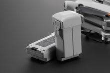 Load image into Gallery viewer, DJI Intelligent Flight Batteries For The DJI Mini 4 Pro, With The Drone Partially Visible In The Background.
