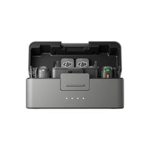 गैलरी व्यूवर में इमेज लोड करें, A gray and black DJI-branded charging dock with two DJI-branded battery packs placed inside, shown on a clean white background.
